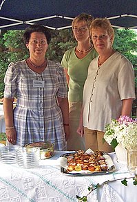 3 Ehrenamtliche in einem Festzelt hinter dem Buffet